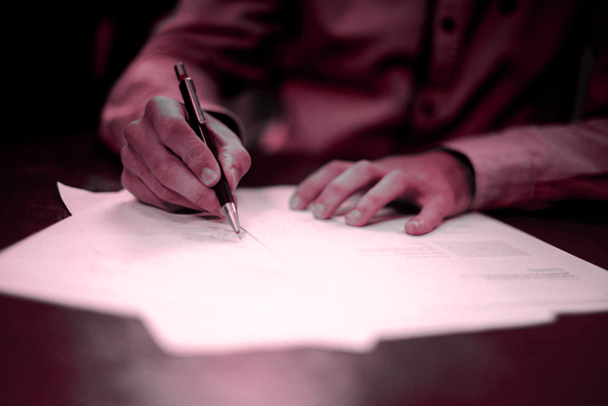 Una persona escribiendo en un papel